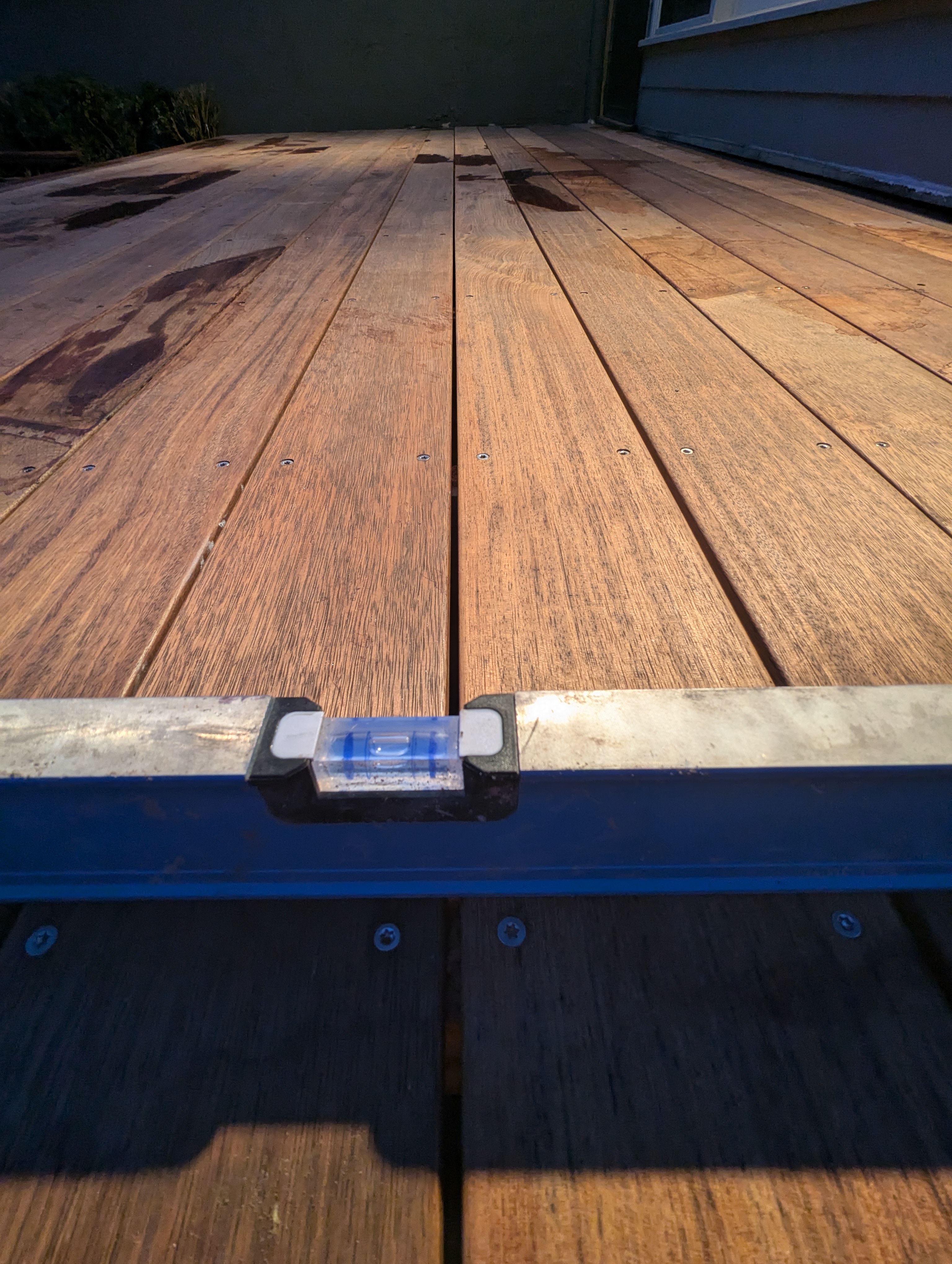 Timber deck boards checked level with a spirit level during installation