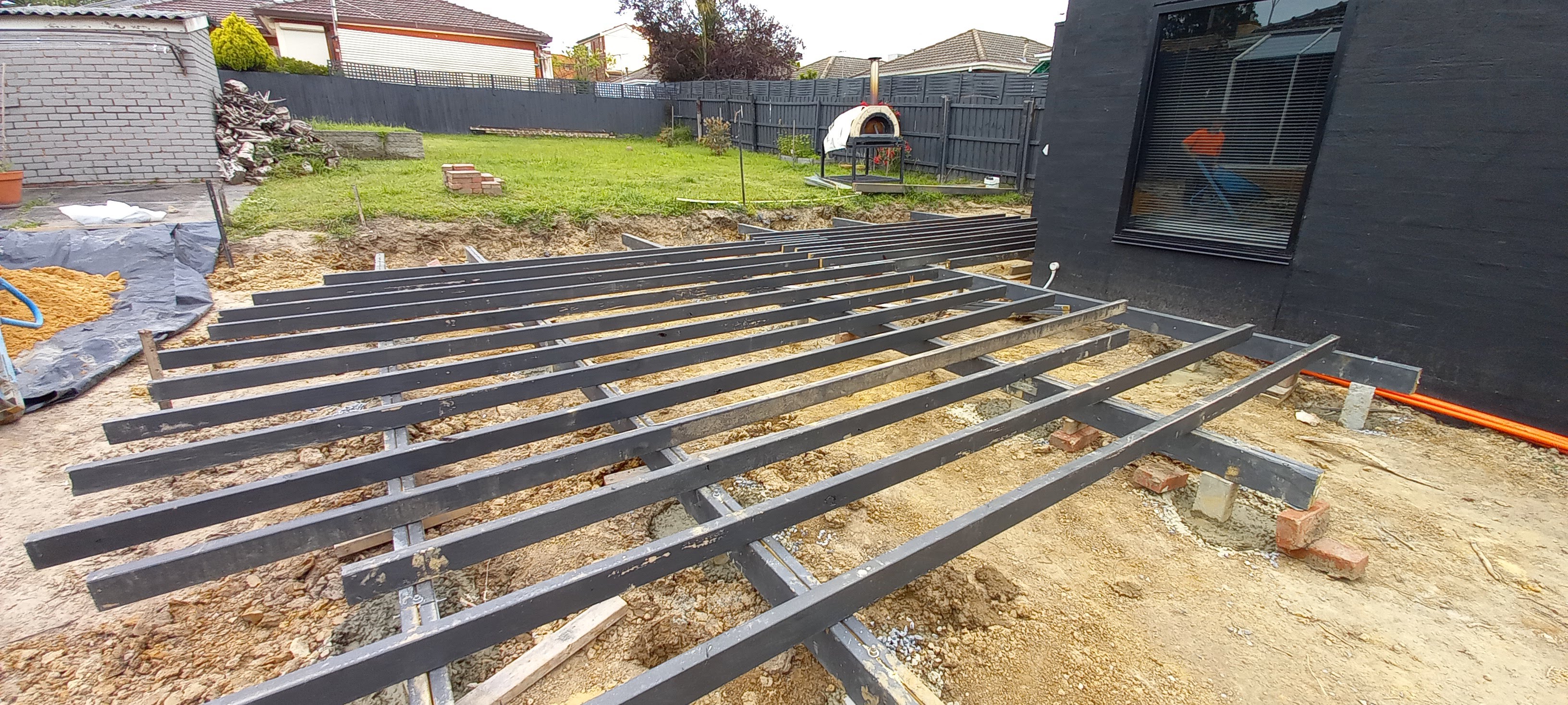 Deck subframe with joists, bearers and concrete footings under construction in a Melbourne backyard